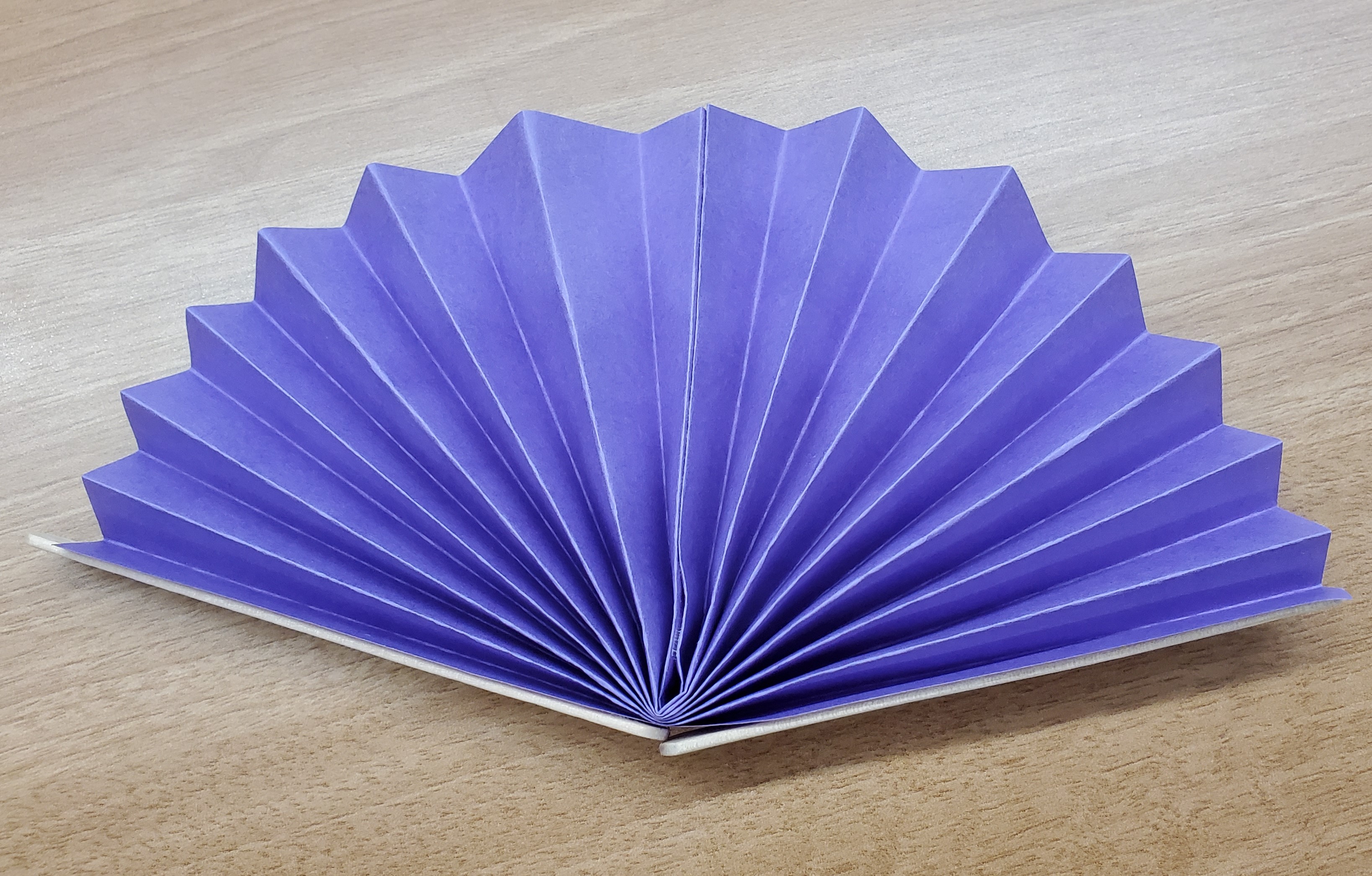 Example of a paper fan craft. Paper fan made from purple construction paper.