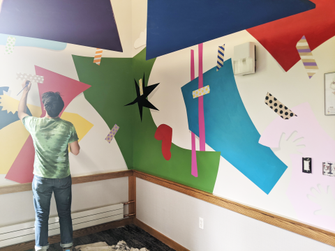 Artist paints the Story Room Mural