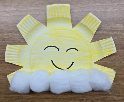 Photo of a sun & clouds craft made of a paper plate and cotton balls.